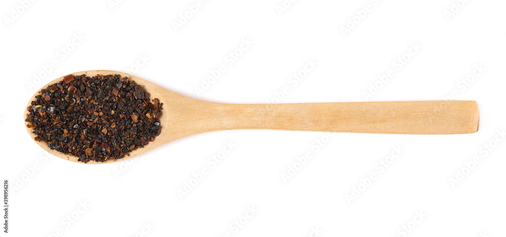 Dry red chili pepper flakes (ancho chilli), cut up paprika pile in wooden spoon isolated on white background, top view Dry red chili pepper flakes (ancho chilli), cut up paprika pile in wooden spoon isolated on white background, top view