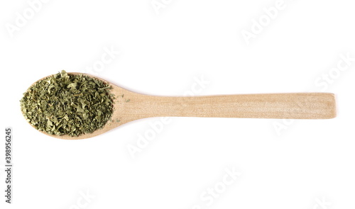 Sliced and cut dry celery leaves pile in wooden spoon, isolated on white background, top view