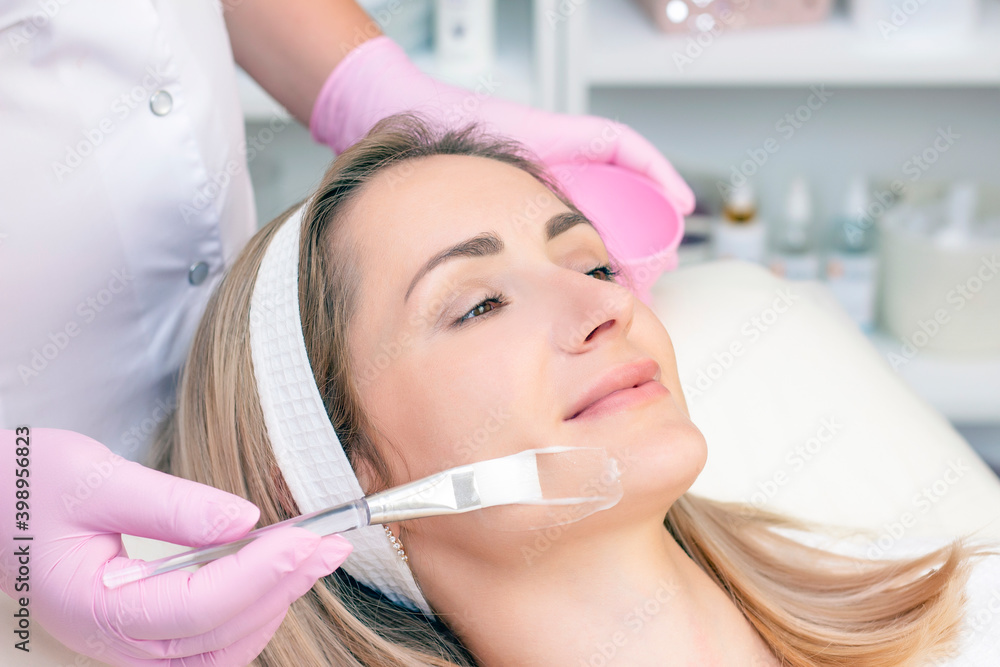 young woman with receiving facial cleansing procedure in beauty salon. young woman with receiving facial cleansing procedure in beauty salon.