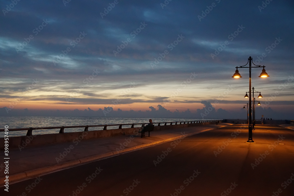 Key West pier and bench with street lamp just before sunrise
