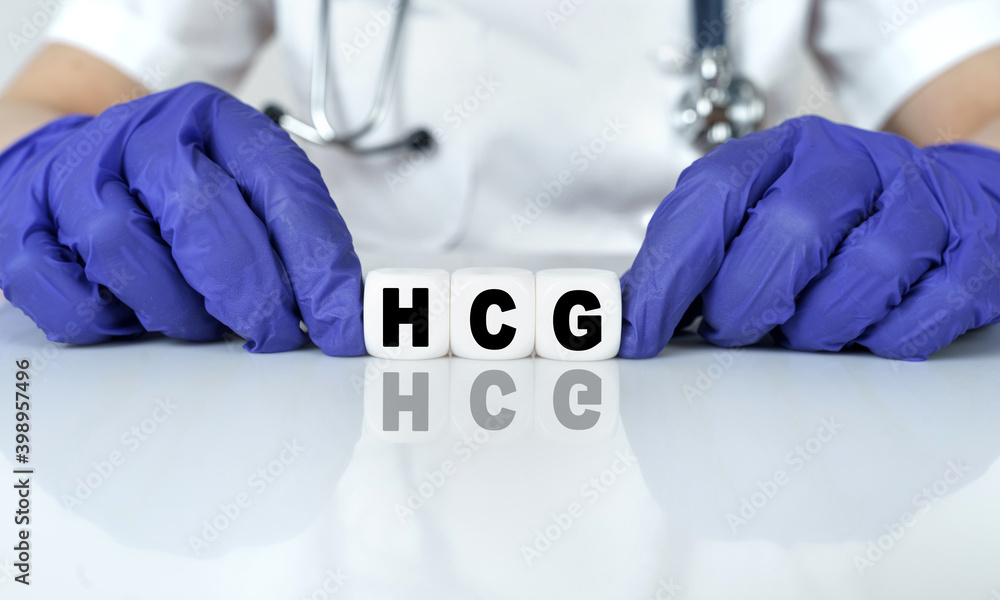 The doctor put together a word from cubes HCG. Human Chorionic Gonadotropin  foto de Stock | Adobe Stock