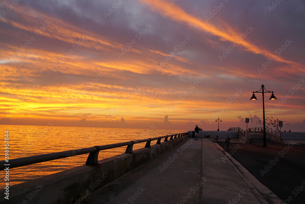 Key west pier at sunrise with street lamps and birds