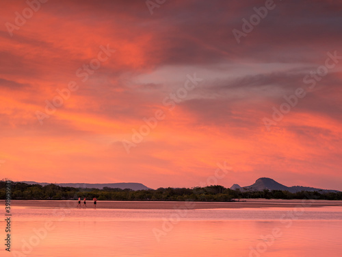 Dramatic Riverbank Sunset with Three men on Sand Bank