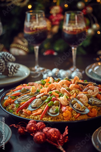 Spanish dinner table with assortment of dishes. paella  octopus  whole fish  sangr  a and wine. Dressed for christmas