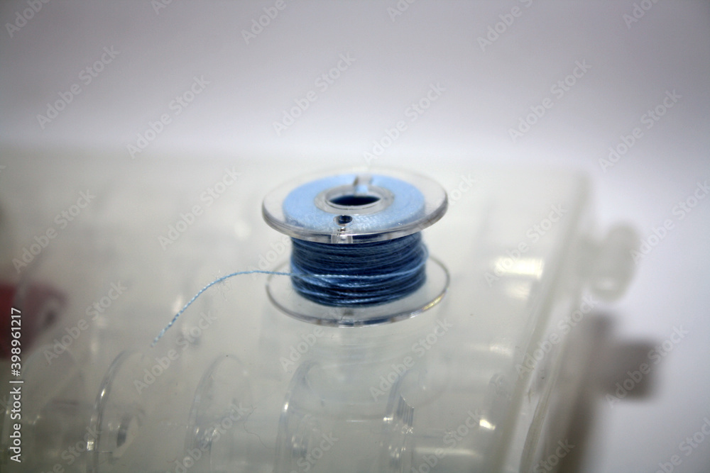 Blue thread wound on a bobbin. Blue thread wound on a bobbin.