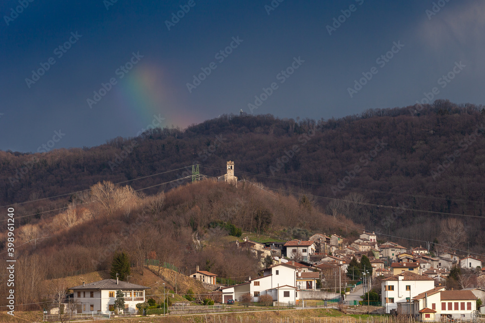 Panorama of church in the Unesco Prosecco Hills with thunderstorm and rainbow in the background, Veneto, Italy
