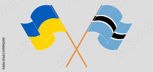 Crossed and waving flags of Ukraine and Botswana