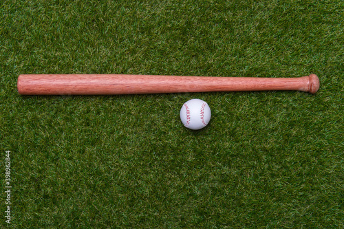 tBaseball bat and ball on green grass field.  Sport theme background with copy space for text and advertisment