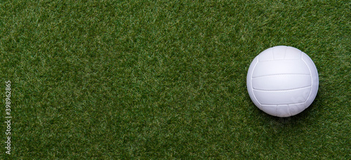 White volleyball ball on green grass. Team sport concept