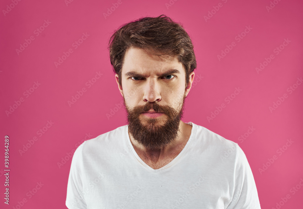 Man with bushy beard on a pink background white t-shirt cropped view Man with bushy beard on a pink background white t-shirt cropped view
