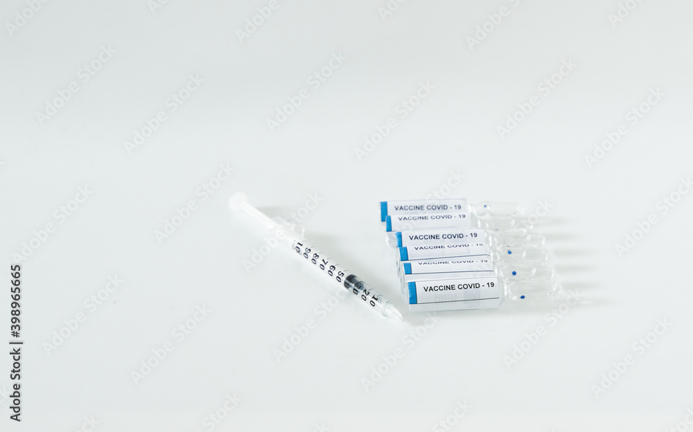 Covid-19 Vaccine bottle and syringe for injection on a white background.     