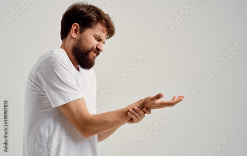 a man is in pain and touches his hand on a light background