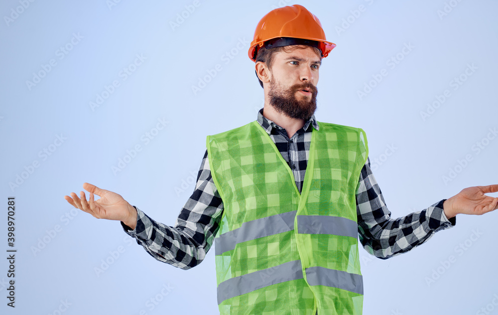 Builder with orange hard hat in hand and reflective vest blue background Copy Space Builder with orange hard hat in hand and reflective vest blue background Copy Space