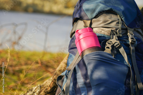 a tourist flask for water is in the pocket of the backpack