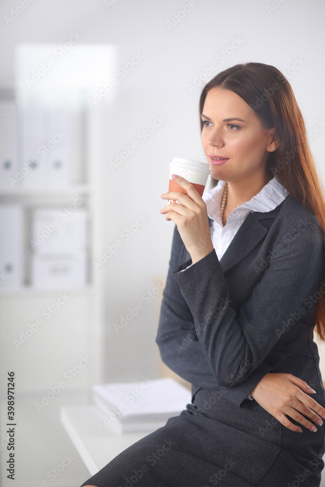 Woman drink coffee at office, standing near desk Woman drink coffee at office, standing near desk