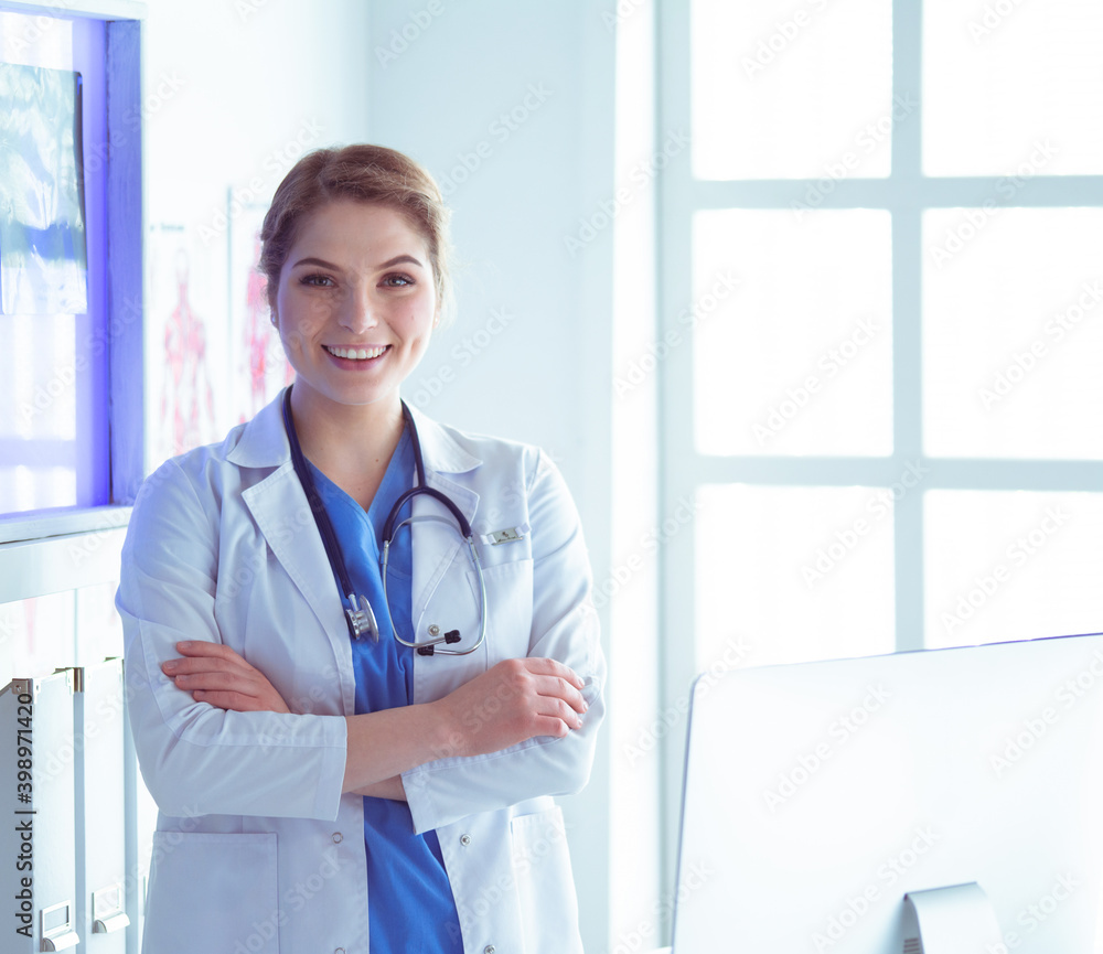 Young woman medic in white uniform standing in clinic's office Young woman medic in white uniform standing in clinic's office