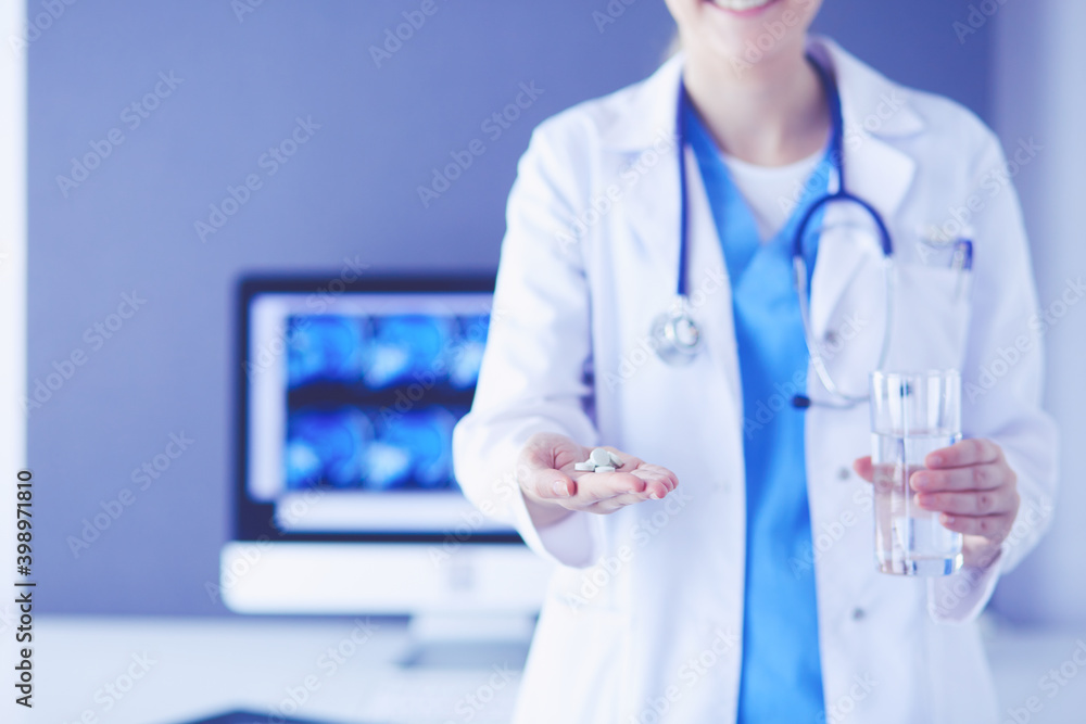 shot of doctor's hands holding pills and glass of water at clinic. shot of doctor's hands holding pills and glass of water at clinic.