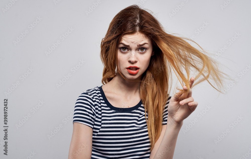Fototapeta premium stylish woman in striped t-shirt holding hair hairstyle smile