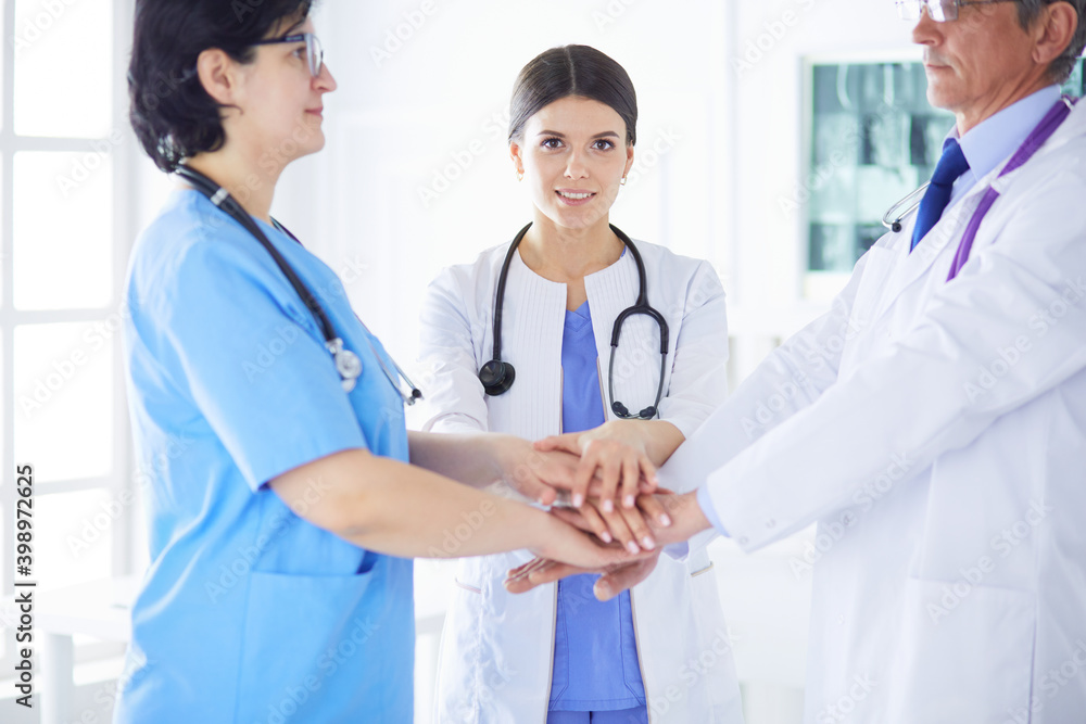 Group of doctors putting their hands together Group of doctors putting their hands together