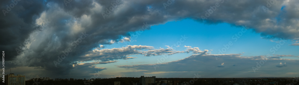 Dramatic dark cloudy sky over the horizon, natural blue background, cloudscape panorama.