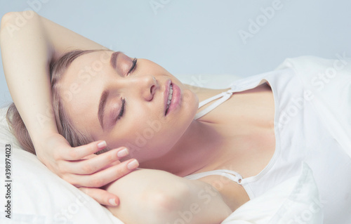 Photo of sleeping young woman lying in bed with eyes closed