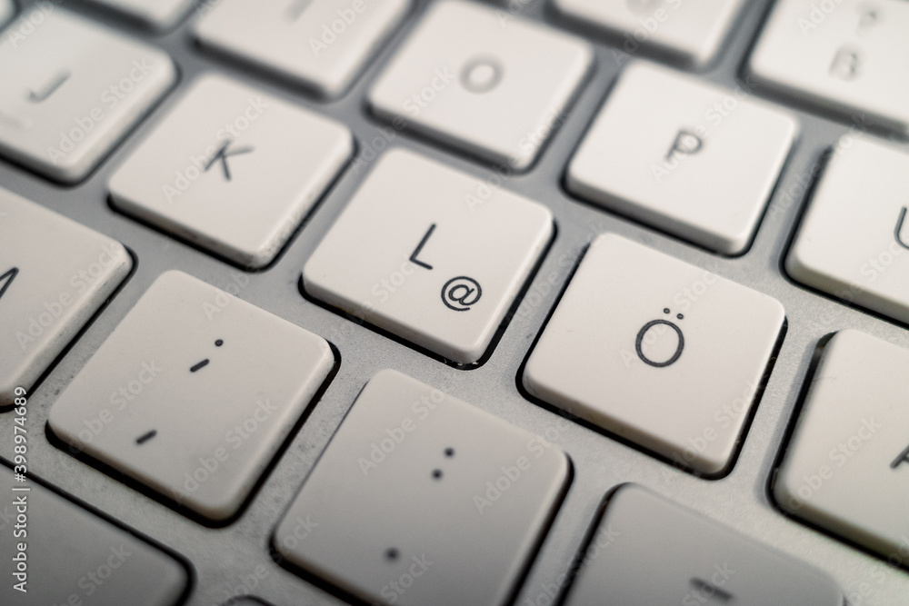 Close up and macro detail view at German alphabet on white buttons of modern aluminium computer's keyboard. Close up and macro detail view at German alphabet on white buttons of modern aluminium computer's keyboard.