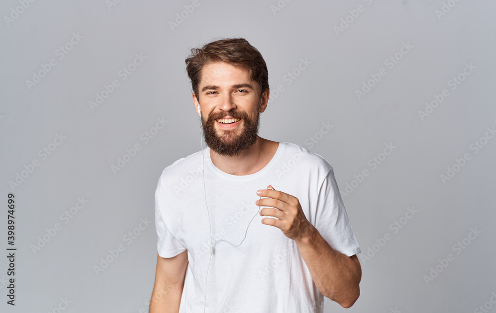 handsome guy in headphones on gray background white t-shirt emotions model handsome guy in headphones on gray background white t-shirt emotions model