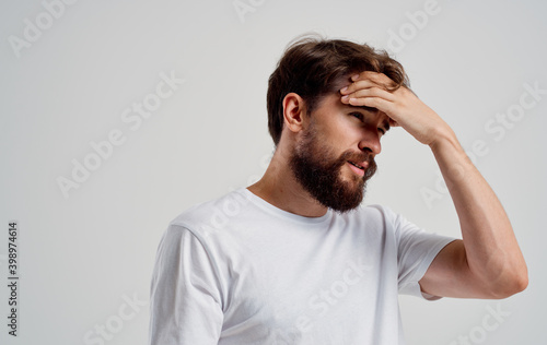 bearded man holding his head pain health problems close-up