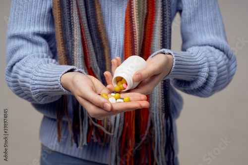 colorful tablets vitamins in a jar female hands scarf model sweater