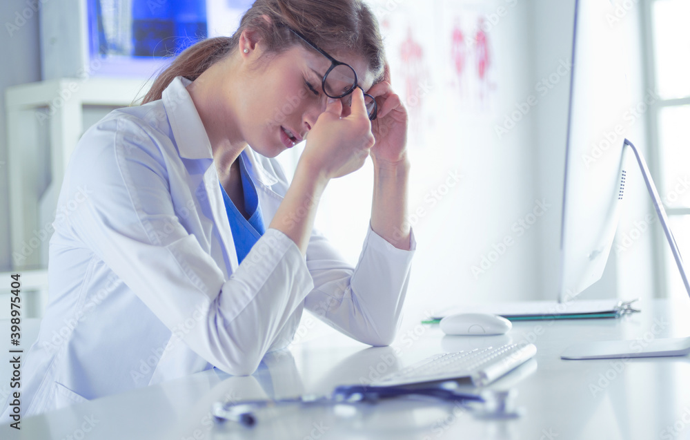 Portrait of a young female doctor suffering from a headache at work Portrait of a young female doctor suffering from a headache at work