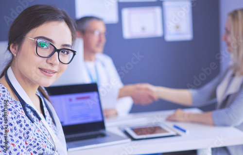 Doctor and patient discussing something while sitting at the table . Medicine and health care concept