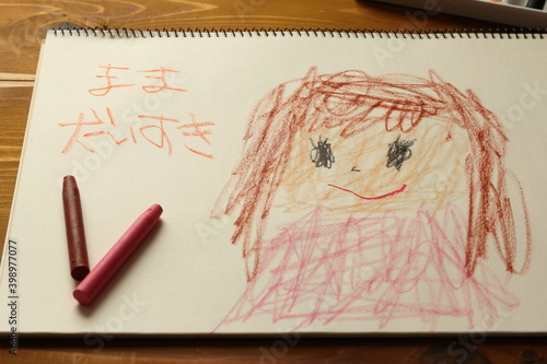 子供がクレヨンでスケッチブックに描いた母親の絵