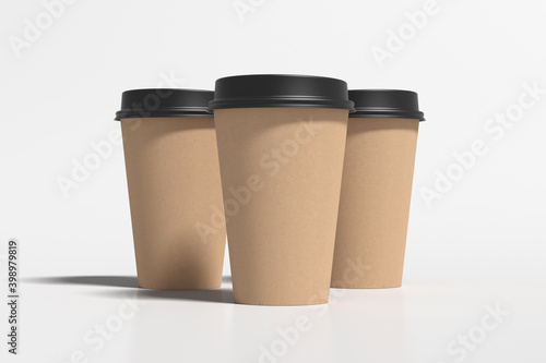 Three cardboard take away coffee paper cups mock up with black lids on white background.