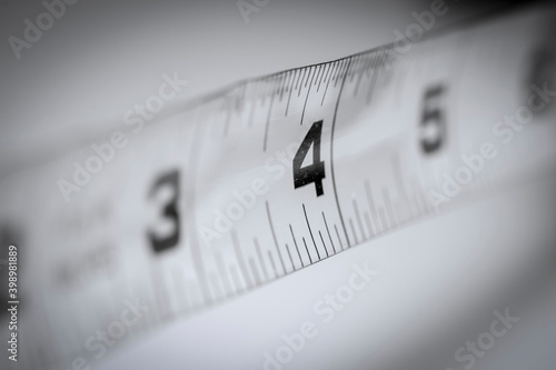 Close up shot of number four inches on old measurement tape 
 photo