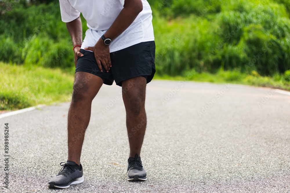 Εκτύπωση καμβά Close up Asian young sport runner black man wear watch hands joint hold leg she