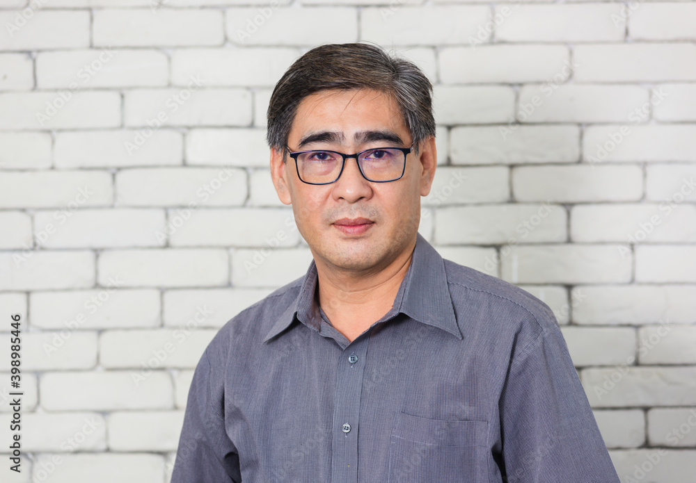 Portrait of Asian handsome senior elderly man wear eyeglasses on white brick wall background. Old man standing golden age grandfather healthcare cheerful lifestyle Portrait of Asian handsome senior elderly man wear eyeglasses on white brick wall background. Old man standing golden age grandfather healthcare cheerful lifestyle