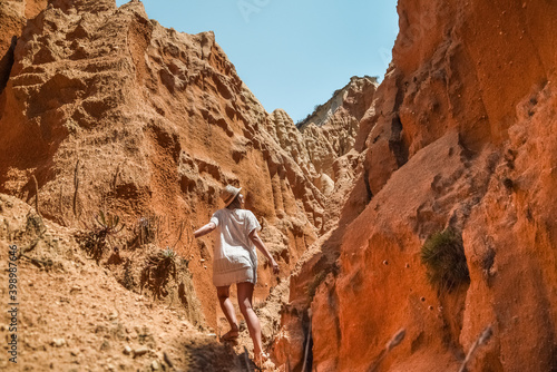 Young woman climbing an orange cliff in Portugal