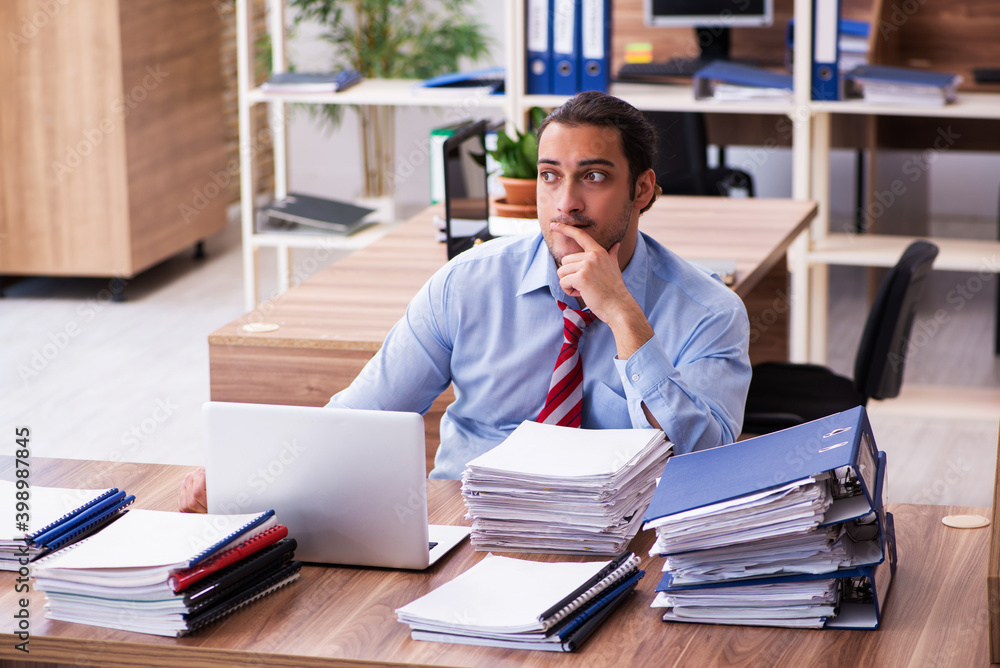 Young male employee unhappy with excessive work Young male employee unhappy with excessive work