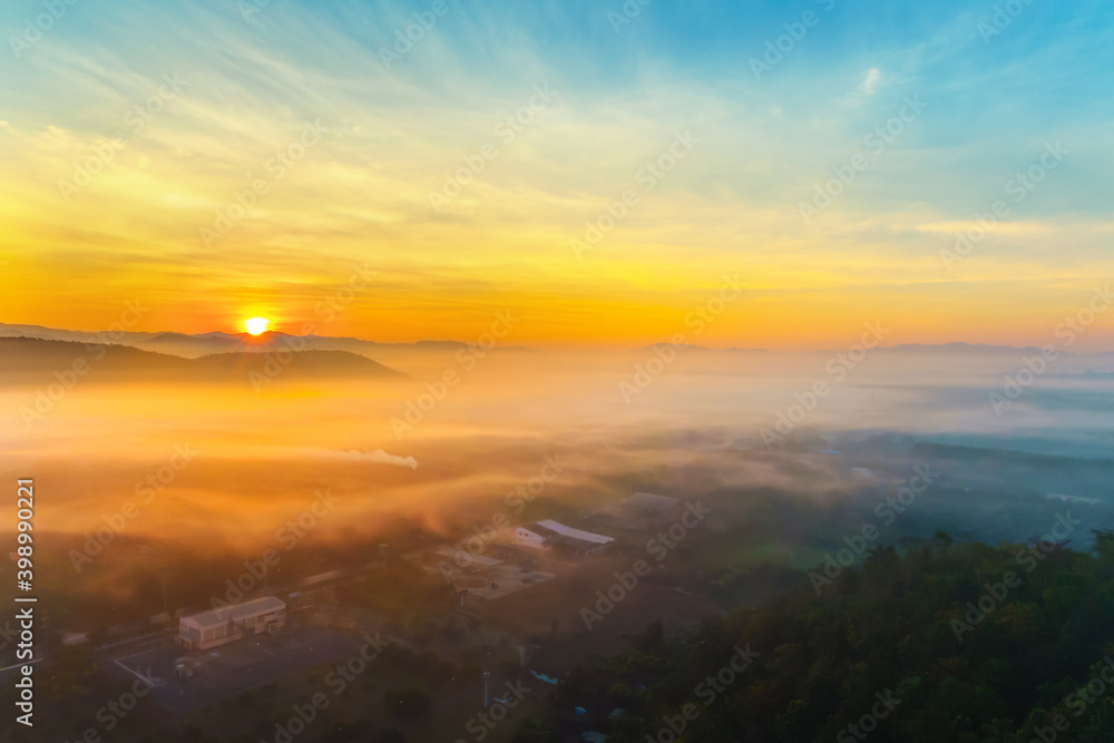 Aerial view of fantastic foggy landscape glowing while sunrise in the morning. Colorful landscape with high mountains foggy cover in sunset or sunrise .Top view. Nature