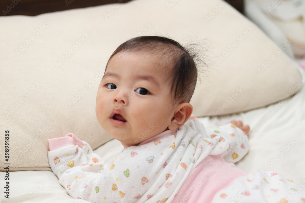 寝室のベッドで寝転がる赤ちゃん