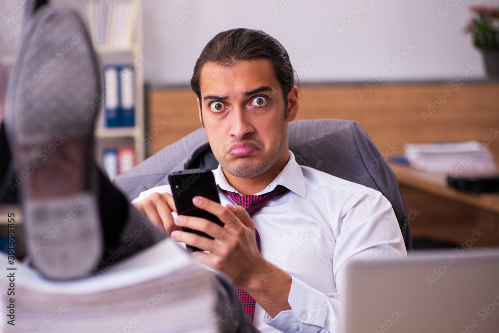 Young male employee extremely tired with excessive work Young male employee extremely tired with excessive work