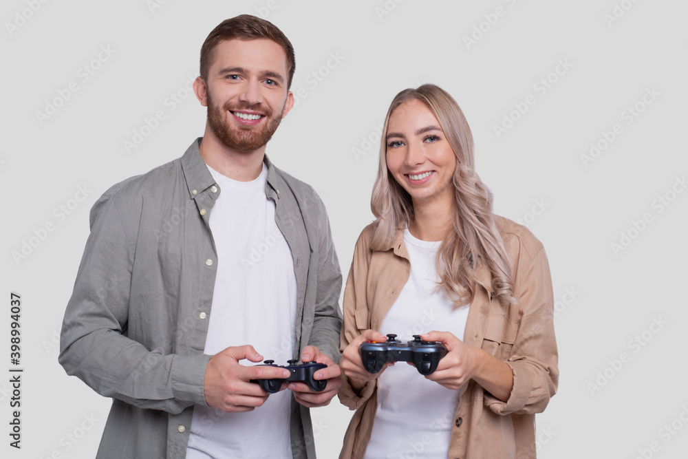 Couple Standing with Joysticks in Hands Smilling Isolated Couple Standing with Joysticks in Hands Smilling Isolated