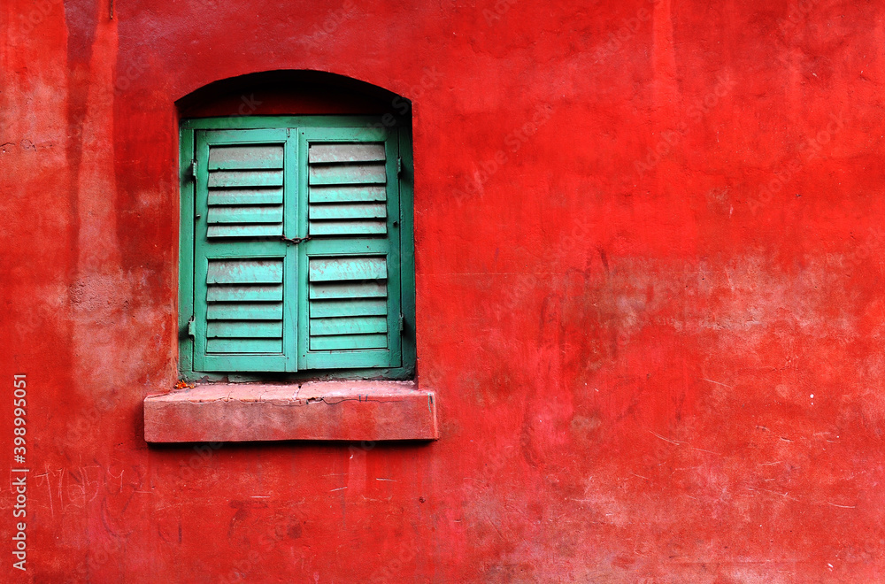 Bright background with green window on the orange red wall Bright background with green window on the orange red wall