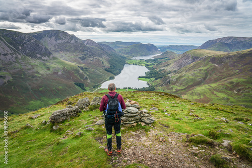 Fototapeta Naklejka Na Ścianę i Meble -  Hiker in Lake District looks at Buttermere lake from Haystacks peak