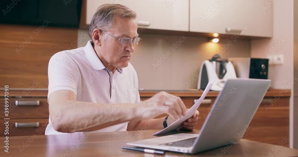 European caucasian confused and uncertain senior man paying online bills using laptop. European caucasian confused and uncertain senior man paying online bills using laptop.