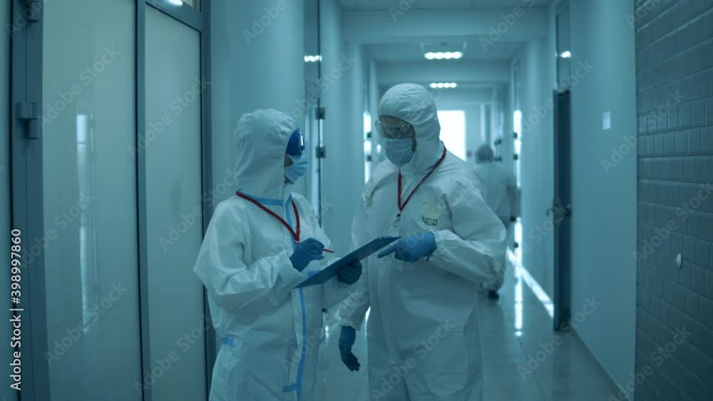 Man and woman in hazmats work together in hospital. Man and woman in hazmats work together in hospital.