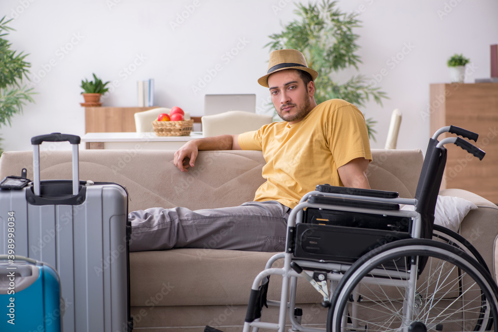 Young man in wheel-chair preparing for departure at home Young man in wheel-chair preparing for departure at home