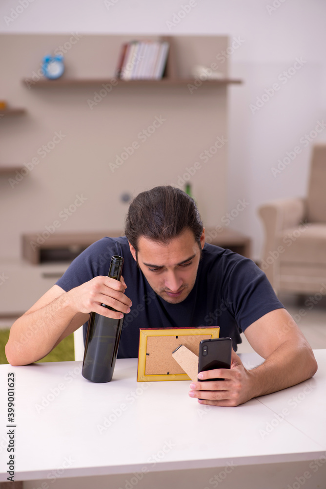 Young male alcoholic suffering from unhappy love at home Young male alcoholic suffering from unhappy love at home
