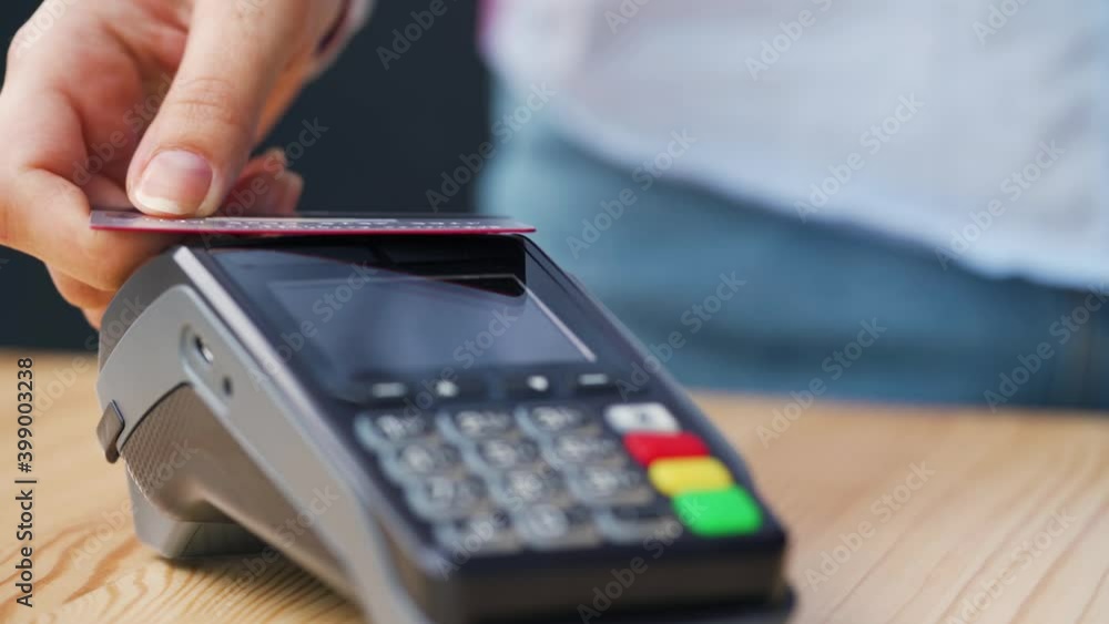 NFC credit card payment. Woman paying with contactless credit card with NFC technology. Wireless money transaction. Wireless payment NFC credit card payment. Woman paying with contactless credit card with NFC technology. Wireless money transaction. Wireless payment