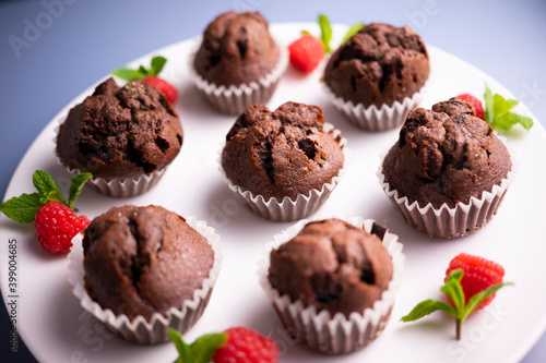 Mini chocolate muffins on a white plate and colour background